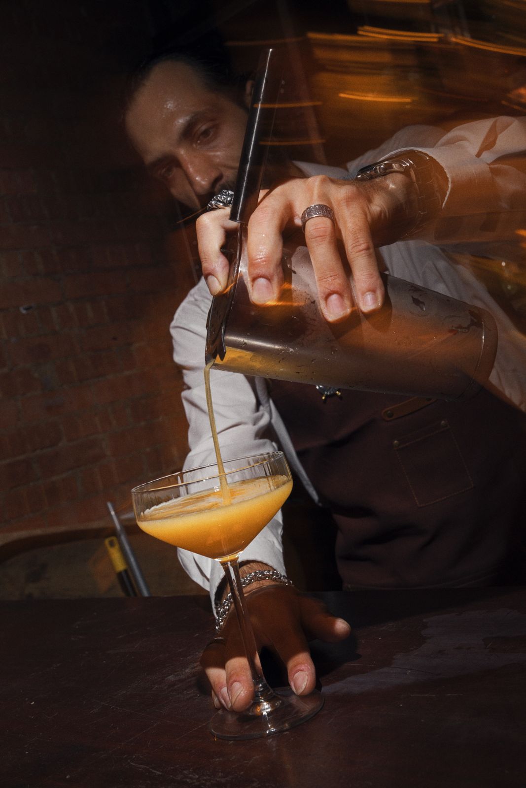 A cocktail being poured at the bar